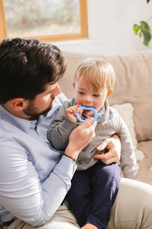baby and dad using ARK Baby Grabber | Light (Baby Blue). Chew motor tool toy.