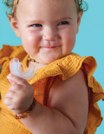 Smiling toddler holding Myo Munchee Mini – early intervention chew device for oral development and functional jaw movement