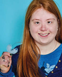 Smiling tween holding Myo Munchee Tween – oral motor tool for improving chewing coordination and tongue posture in older children