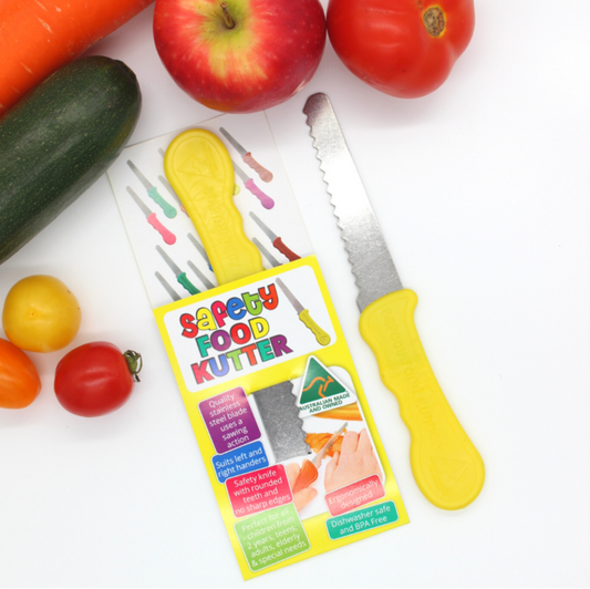 Yellow safety food knife shown with packaging and fresh produce – perfect for kids’ cooking skills and potentially NDIS-eligible life skills therapy tool