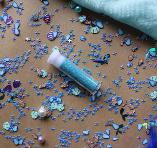 Flat lay of Calm Down Bottle refill pack contents – blue glitter, sequins, and calming items ready for sensory bottle creation