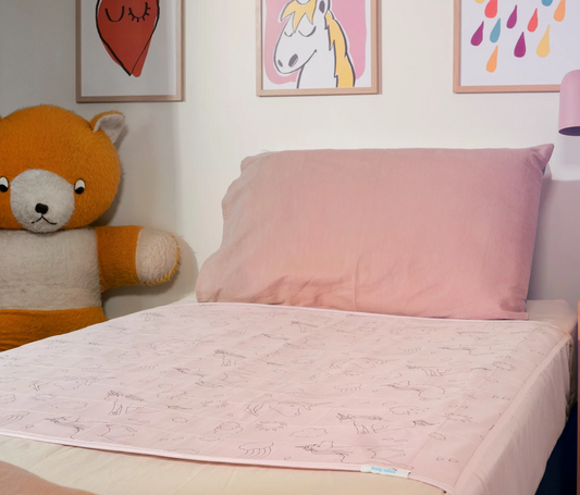 Children's room with a bed, brolly sheet, teddy bear, and colorful wall art.