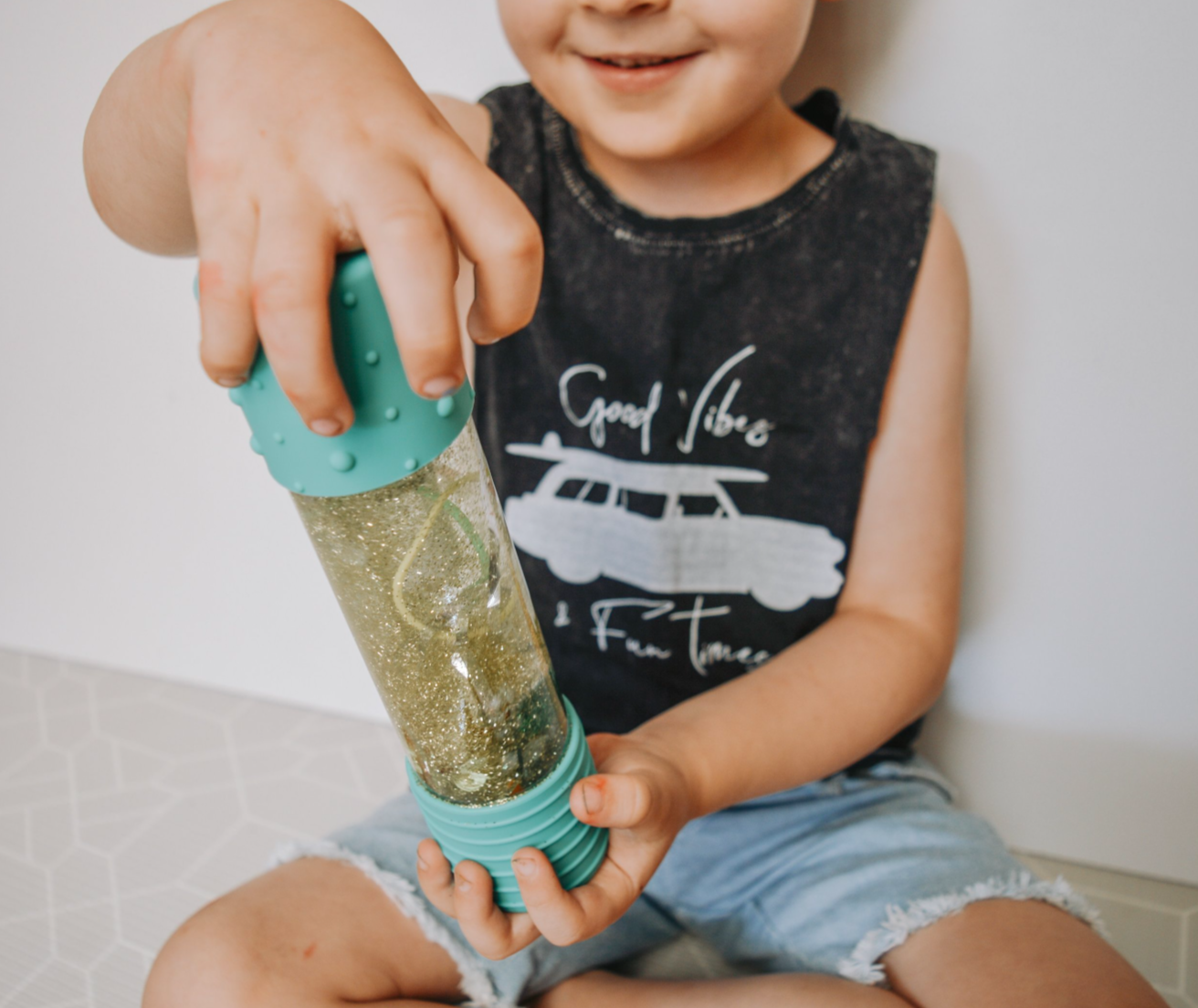 Child shaking a DIY Calm Down Bottle filled with glitter – supporting emotional regulation and visual sensory play
